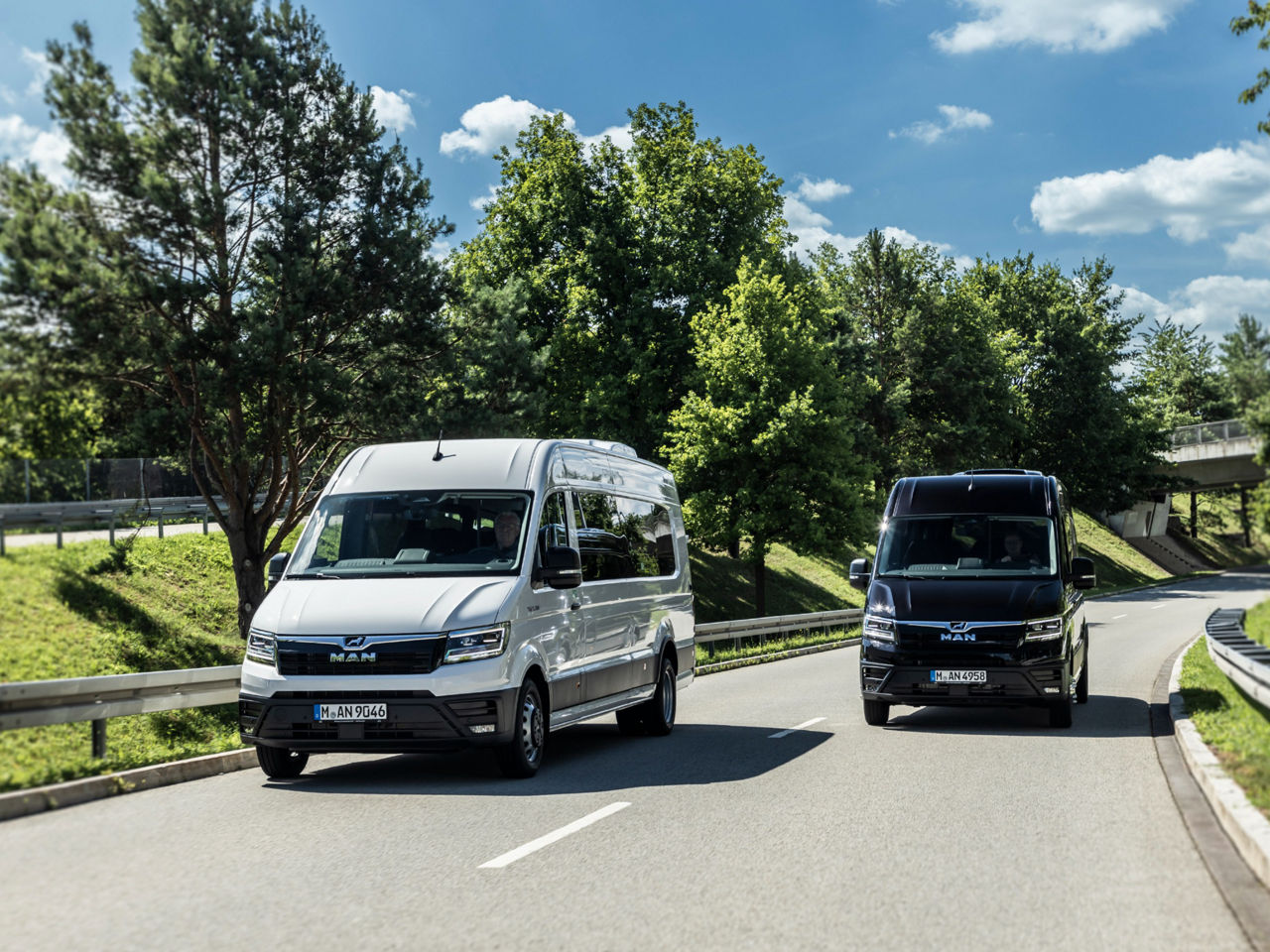 Zwei MAN TGE Minibusse fahren nebeneinander